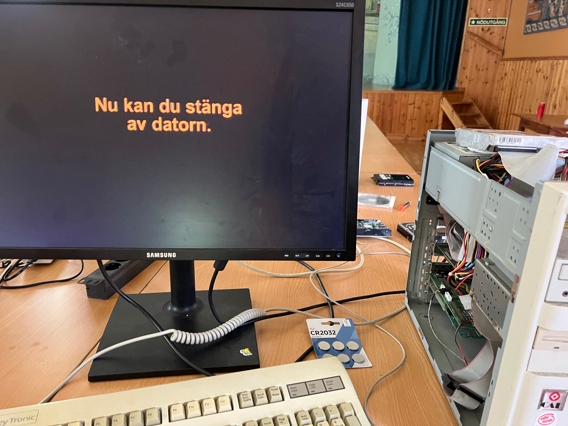 Äldre stationär dator med öppen kåpa och bildskärm som visar 'Nu kan du stänga av datorn'.
